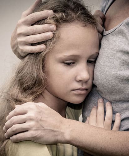 upset-girl-hugging-mom A young girl looking sad while getting a hug.