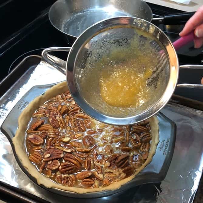shows cooked egg bits left in fine mesh strainer from a pecan pie
