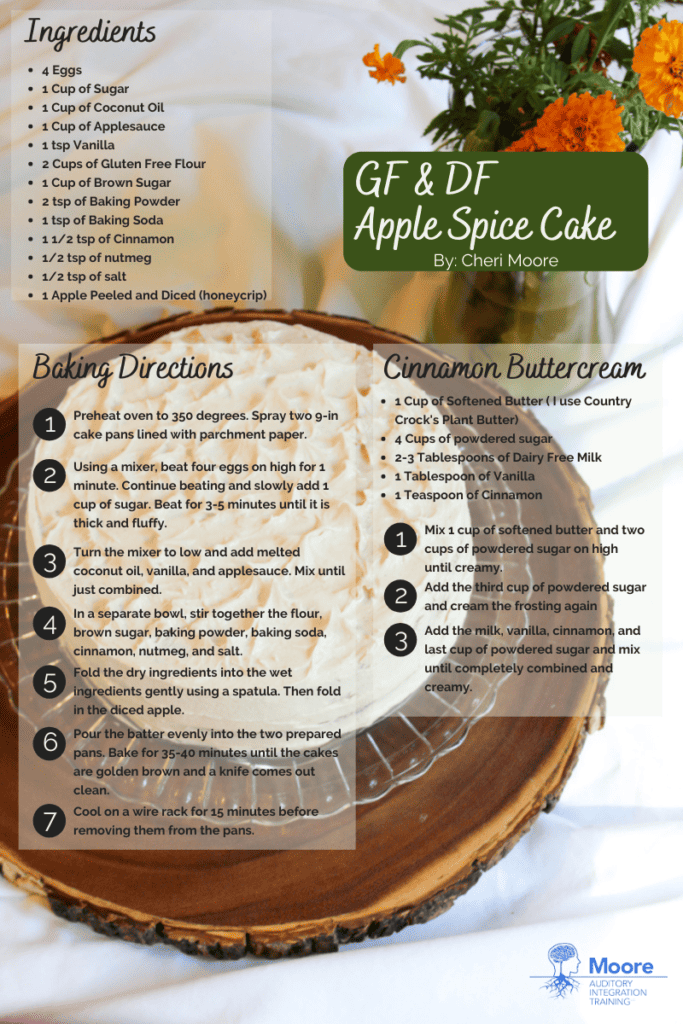 Printable gluten and dairy free apple spice cake recipe card. text is in black. Title of the recipe is written in white on top of a dark green rounded edge rectangle. The background image is the apple spice cake on a crystal platter sitting on a wooden tree slice. The background is white linen and there is a vase of orange marigolds in the upper right hand corner.