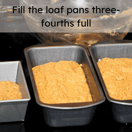 Gluten free pumpkin bread batter distributed into two loaf pans and one mini loaf pan. They are sitting on the black cooktop. 