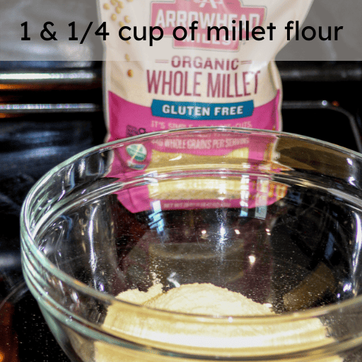 millet flour in a glass bowl sitting on a black glass stovetop with the bag of millet sitting behind it