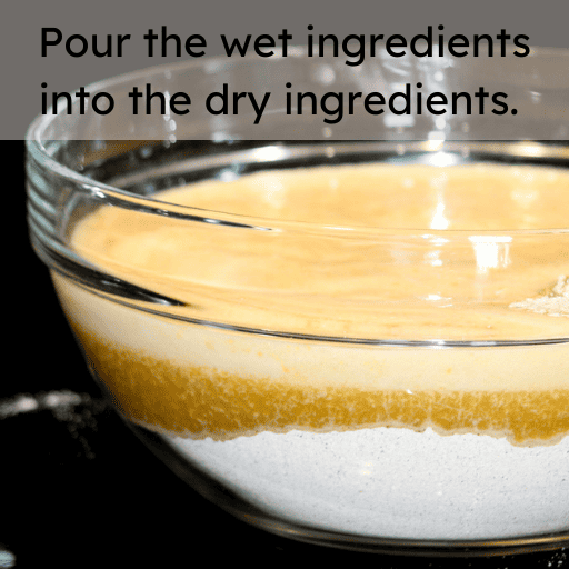 Wet and dry ingredients for gluten free pumpkin bread both sitting in a large glass bowl on a black surface. The ingredients have not been mixed yet.