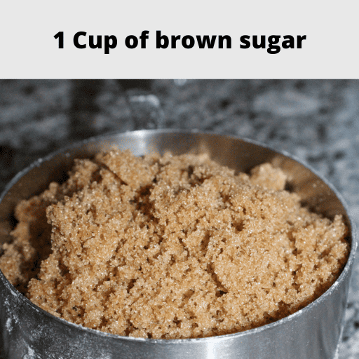 1 cup of brown sugar in a stainless steal 1 cup measuring cup sitting on the counter. 