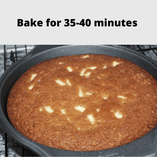 Baked apple spice cake in the pan sitting on a cooling rack. 