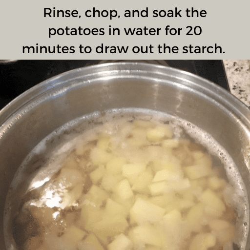 Chopped potatoes in a stainless steel pot on a stovetop. The potatoes are submerged in water. There is a gray box with black text at the top. 