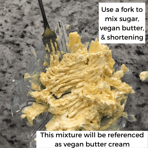 Sugar, butter, and shortening for a gluten and dairy free pie crust mashed together in a glass bowl sitting on the countertop. There is a fork in the bowl.