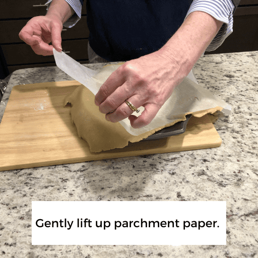 lifting the wax paper off the pie crust in the pie dish. 