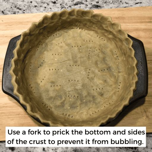 gluten and dairy free pie crust with a scalloped edge sitting in a pie dish. It has been pricked with a fork on the bottom and edges to prevent bubbling.