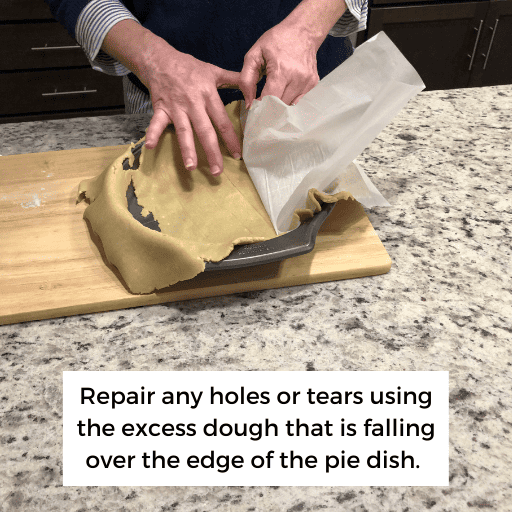 peeling the wax paper off the crust. The crust has torn in a few spots. 