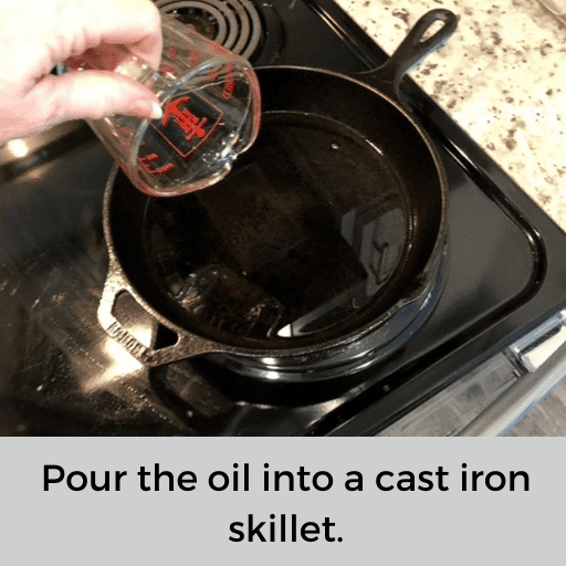 Oil being poured into a cast iron pan. 