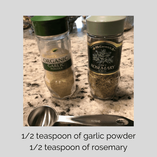 garlic powder and rosemary seasoning jars on the countertop with a 1/2 tsp measuring spoon