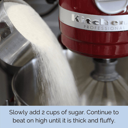 1 cup of cane sugar being poured into a red kitchenaid stand mixer. The sugar is in a stainless steel 1 cup measuring cup.