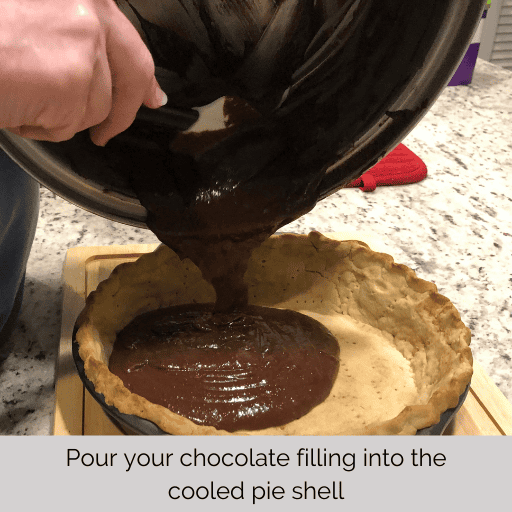 Pouring the chocolate pudding into the pie shell for the homemade gluten and dairy free chocolate meringue pie