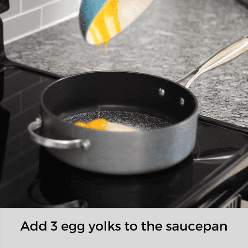 Adding the egg yolks to the saucepan on the stovetop
