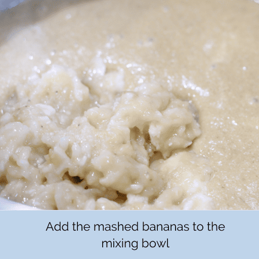 Mashed bananas in a clump in a mixing bowl with the gluten and dairy free chocolate chip banana bread batter.