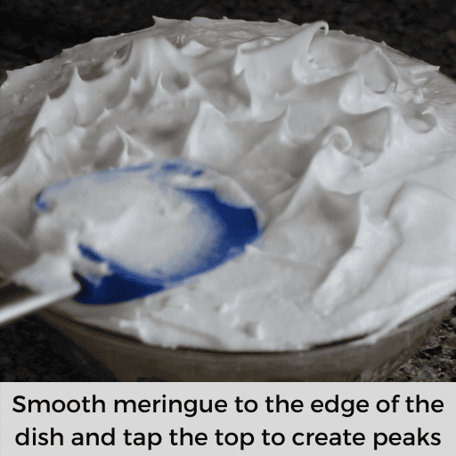Tapping the top of the meringue with a blue spatula to create peaks. 
