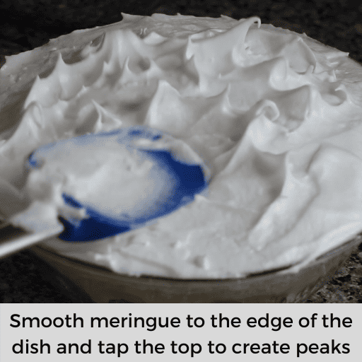 Tapping the top of the meringue with a blue spatula to create peaks.