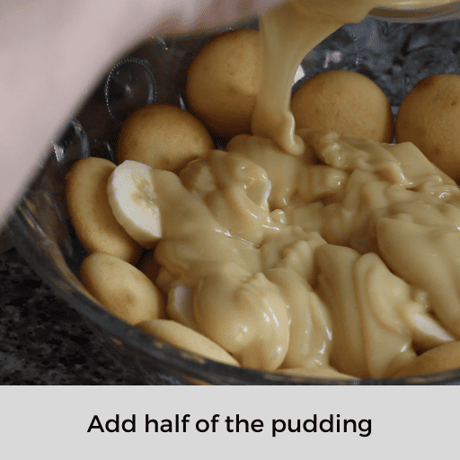 Adding half of the pudding on top of the sliced bananas in the pudding dish