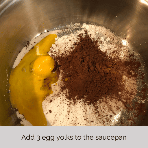 egg yolks added to the saucepan of the dry ingredients for the chocolate pudding part of homemade gluten and dairy free chocolate meringue pie.