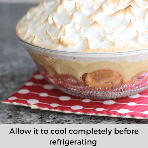 Gluten and dairy free banana pudding with browned meringue sitting on a red and white hot pad on the countertop.