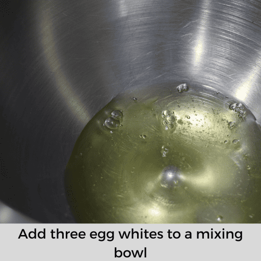 three egg whites in a stainless-steel mixing bowl