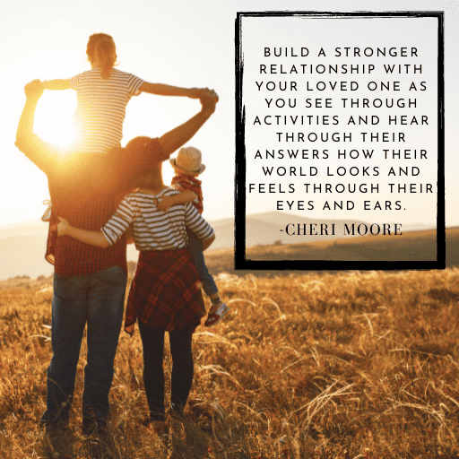 family of four looking at the countryside at sunset. Their backs are to the camera. The wife has an arm around the husband and is holding the youngest. The father has their daughter on his shoulders with his hands holding her hands.