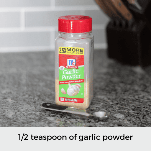 1/2 teaspoon sitting in front of a container of garlic powder