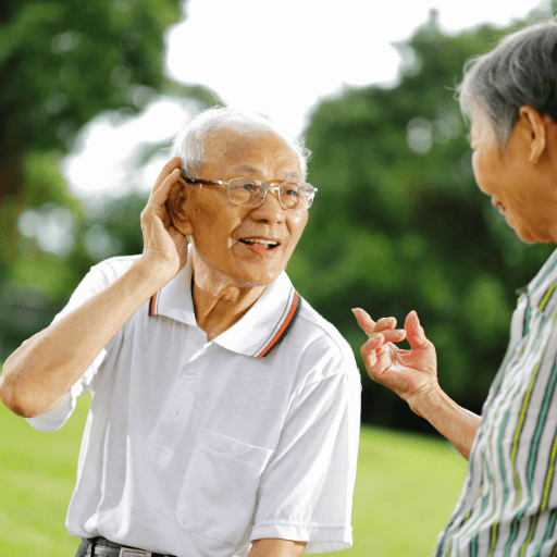 elderly man showing hearing loss behavior in conversation by cupping a hand behind his ear