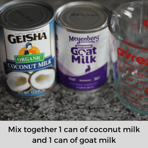 A can of goat milk and coconut milk sitting on the countertop next to the two cup glass measuring cup