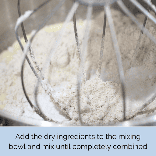 Mixing wet and dry ingredients for gluten and dairy free chocolate chip banana bread together in a stand mixer with the whisk attachment.