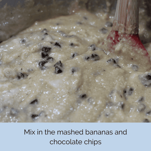 gluten and dairy free chocolate chip banana bread batter all stirred together in a mixing bowl with a red tipped wooden spatula.