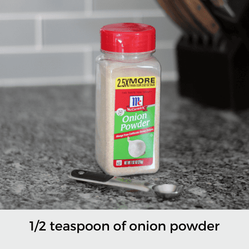 1/2 teaspoon sitting in front of a container of onion powder