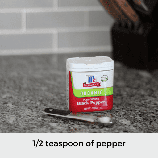 1/2 teaspoon sitting in front of a container of pepper