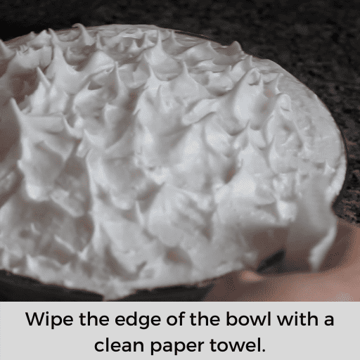 Wiping the edges of the bowl clean with a paper towel