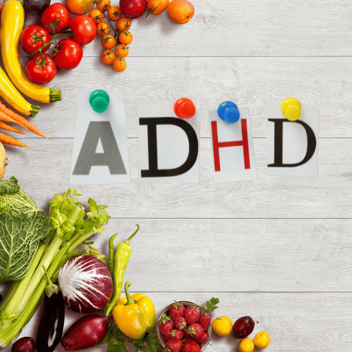 the letters A D H D held up with a thumb take on white washed boards with veggies on the left side