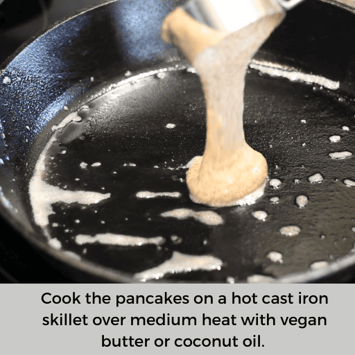 pouring gluten and dairy free pancake batter onto a hot and oiled cast iron skillet using a measuring cup