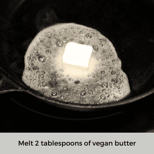 two tablespoons of vegan butter melting in a hot cast iron skillet