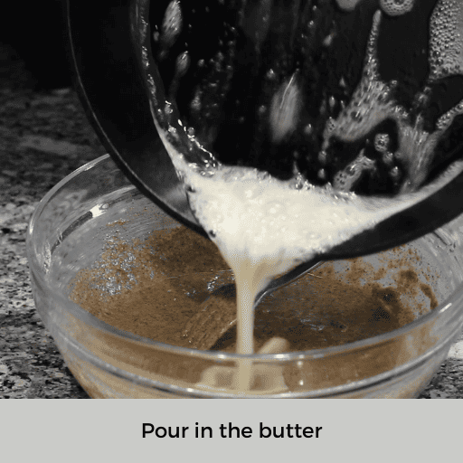 melted butter being poured into the gluten and dairy free pancake batter from a cast iron skillet