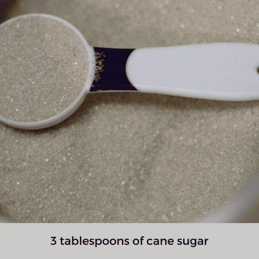 a tablespoon of sugar sitting on top of a mound of sugar. 