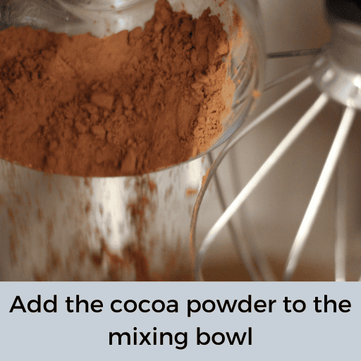cocoa powder being poured into a mixing bowl out of a glass bowl