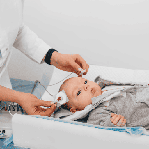 A baby laying down to complete a hearing test