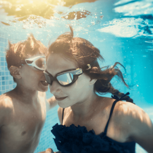 a boy and girl playing the listening game underwater in a pool. They are both wearing goggles. The boy is talking, and the girl is listening. 