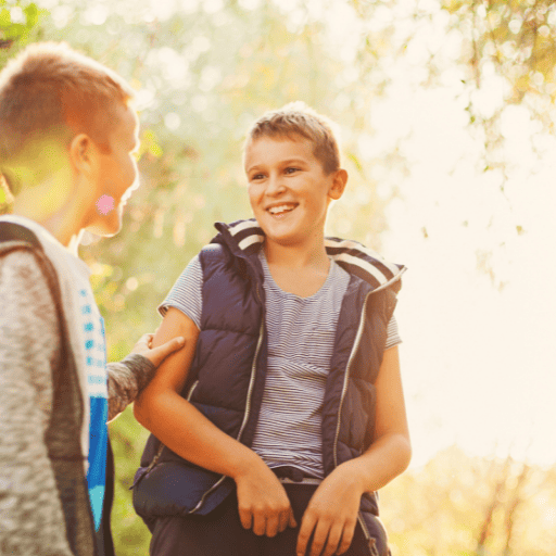 two preteen boys talking with expressive speech outside