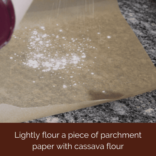 cassava flour being sprinkled on a piece of parchment paper. 