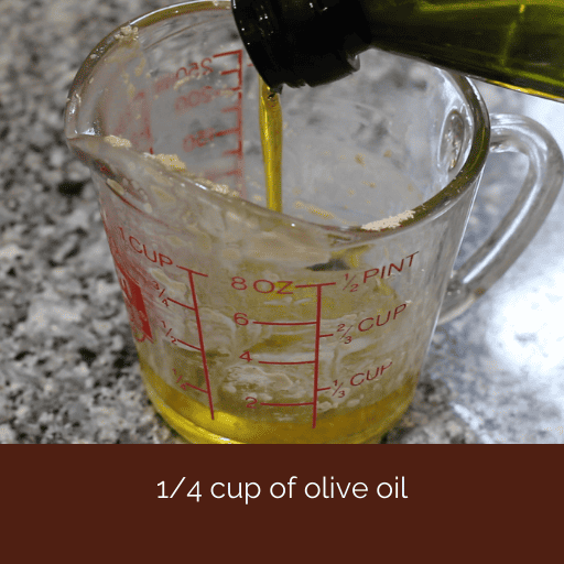 olive oil being poured into a glass measuring cup. 