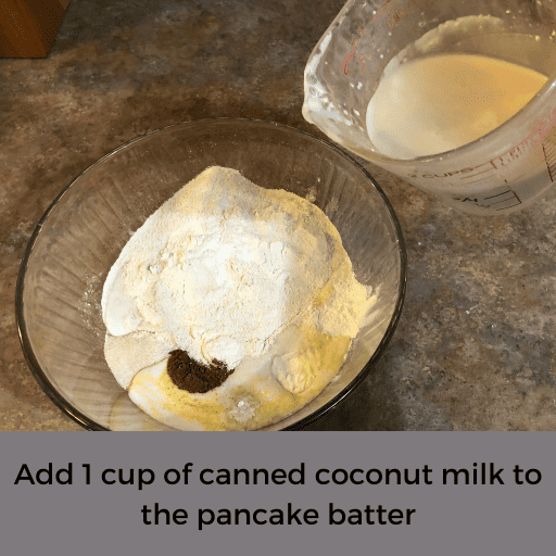 pouring canned coconut milk into a glass mixing bowl of dairy and gluten free apple pancake mix