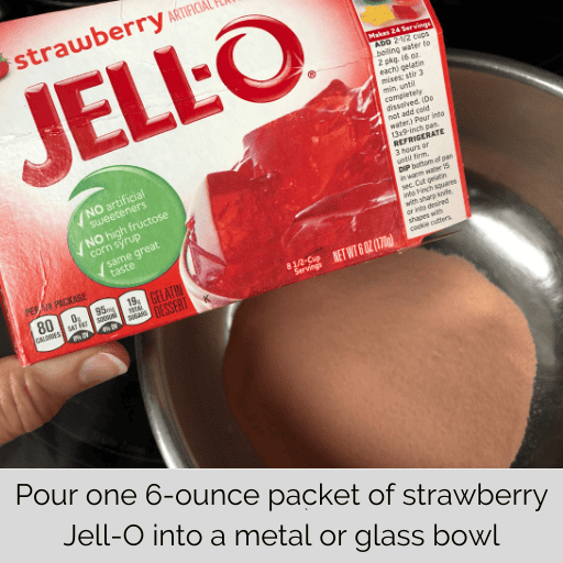 packet of strawberry jell-o emptied into a metal mixing bowl