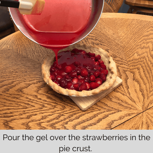 gel being poured over the strawberries to make a gluten and dairy free strawberry pie
