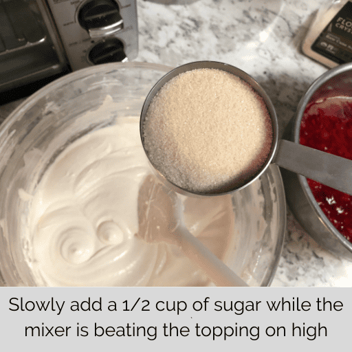 1/2 cup of sugar held above the whipped topping in the mixing bowl