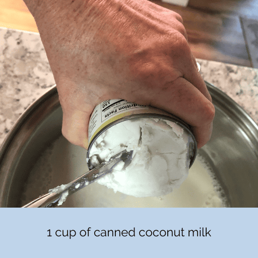 scooping out canned coconut milk into a pot to make homemade sweetened condensed milk for homemade ice cream